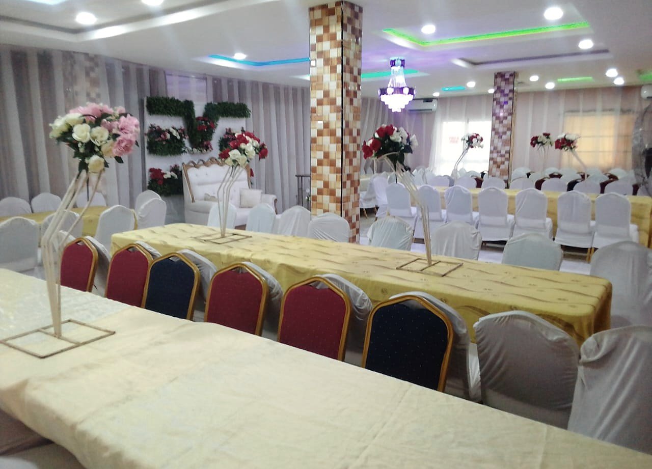 Banquet tables under gold runners, set for a reception at Ezeemabi Hub